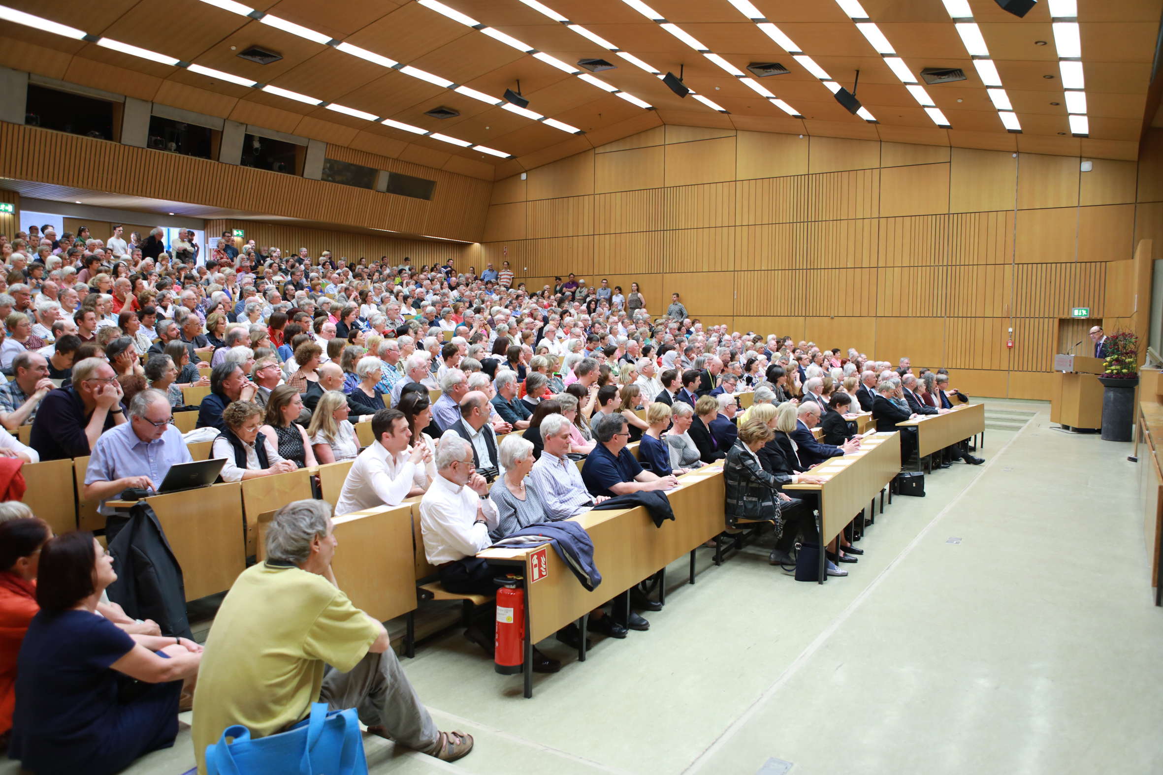 Das Bild zeigt einen vollen Hörsaal beim Symposium zum 90. Geburtstag von Hans Küng.