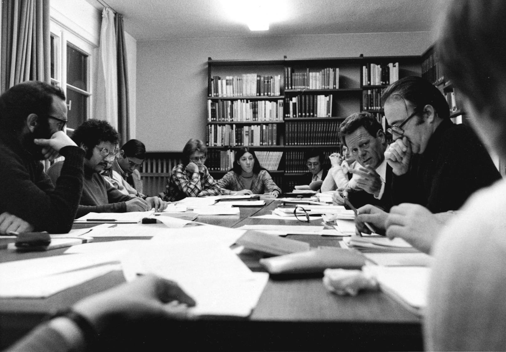 Das Bild in schwarz-weiß zeigt Hans Küng 1963 an einem Tisch mit Studenten beim gemeinsamen Studium im Institut für ökumenische Forschung der Universität Tübingen.