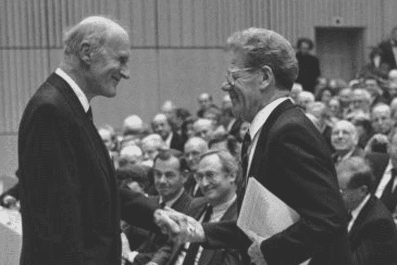 Hans Küng und der Stifter Karl Konrad Graf von der Groeben schütteln sich die Hand im Hörsaal der Universität Tübingen