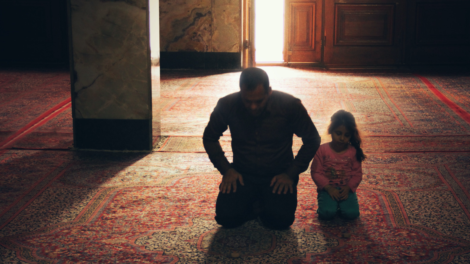 Ein Mann und ein Kind beten in der Moschee.