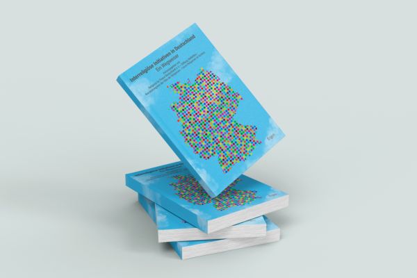 Ein Bücherstapel der Publikation "Interreligiöse Initiativen in Deutschland - ein Wegweiser".