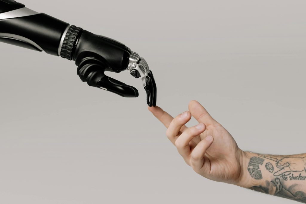 Eine menschliche Hand und eine Hand von einem Roboter berühren sich mit dem Zeigefinger