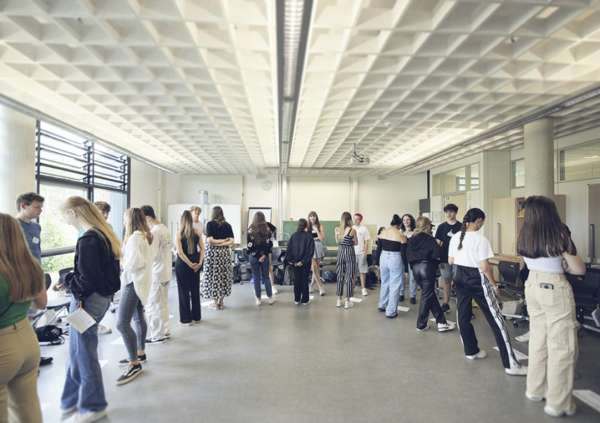Das Foto zeigt Schüler*innen, die sich im Klassenzimmer verteilt gegenüber stehen, während eines worldlab Workshop für Demokratiekompetenz.