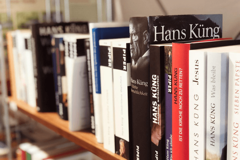 Ein Regal mit den Buchrücken der Bücher von Hans Küng