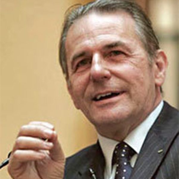 Das Bild zeigt den IOC-Präsidenten Jacques Rogge 2006 in der Nahaufnahme am Rednerpult für Weltethos Reden.