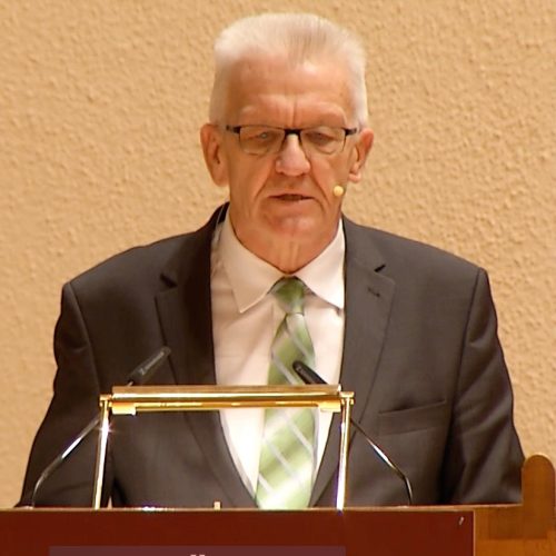 Das Bild zeigt den Ministerpräsidenten von Baden- Württemberg Winfried Kretschmann 2017 an einem Rednerpult für Weltethos Reden.