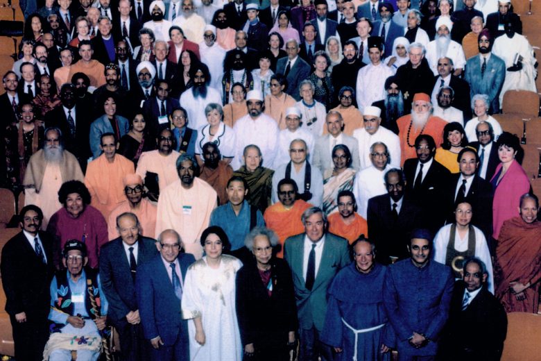 Das Bild zeigt eine große Gruppe von Menschen in bunten Gewändern beim Parlament der Weltreligionen für Weltethos Tübingen, alle blicken in die Kamera.